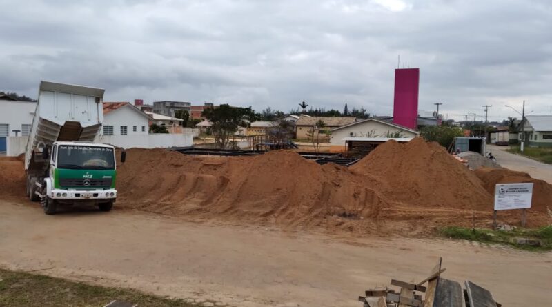 Caminhões levam aterro até o local da obra da nova creche.